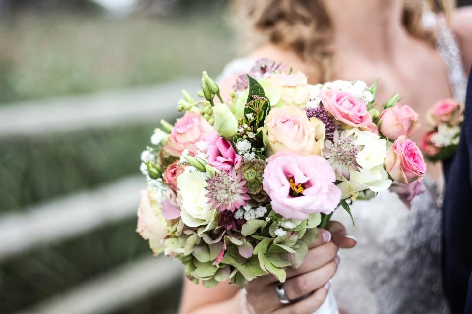 Novia sosteniendo un ramo de flores rosas