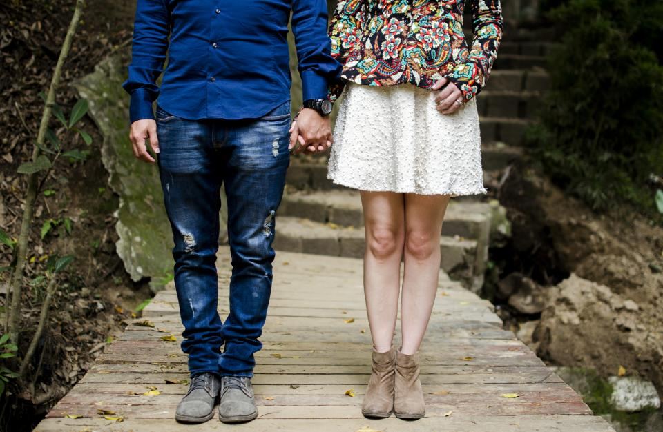 Pareja de pie tomada de la mano